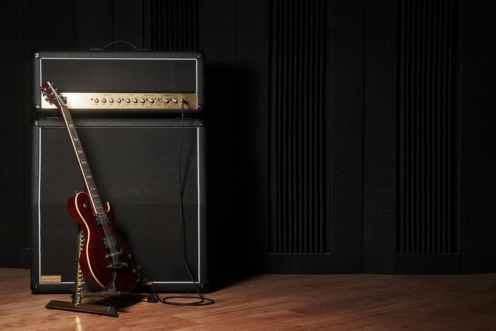 Electric Guitar Leaning Against A Black Amplifier Stack — Kennedy Amplifier Hire Service In South Mackay, QLD