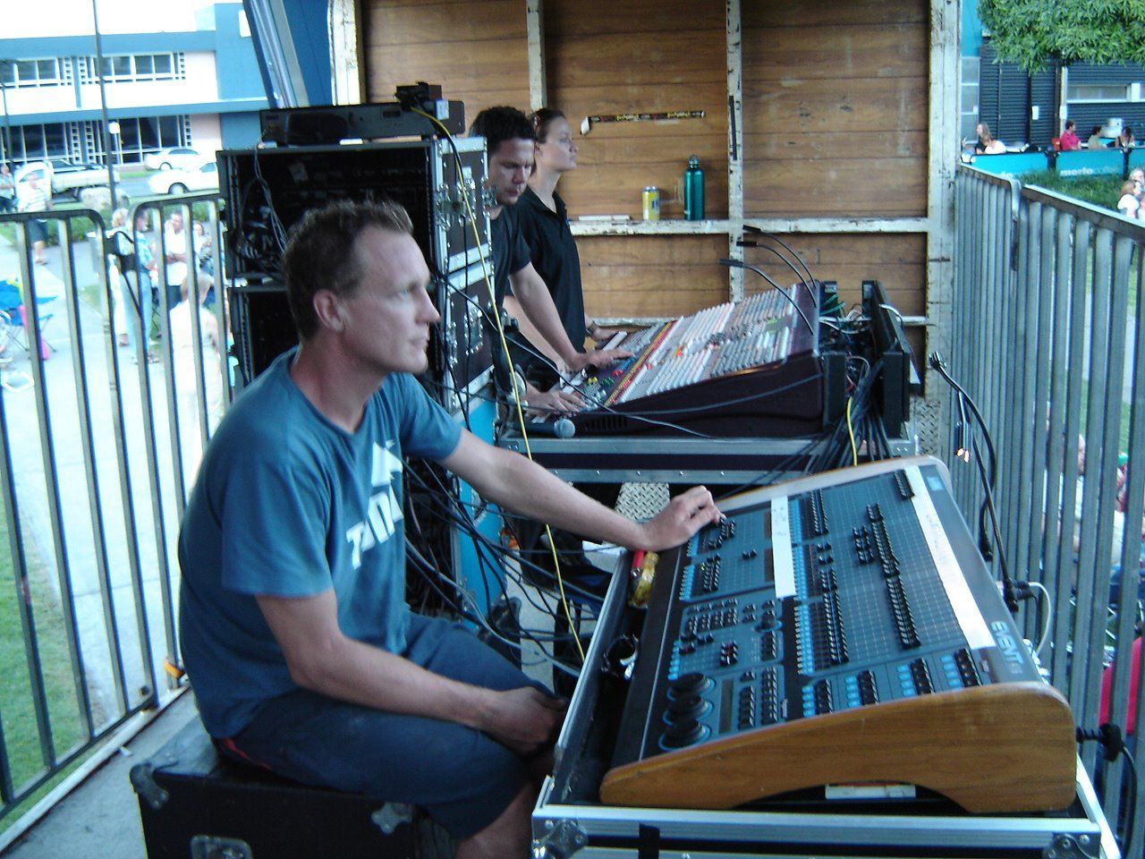 Two Men Operating Soundboards On An Outdoor Stage — Kennedy Amplifier Hire Service In South Mackay, QLD