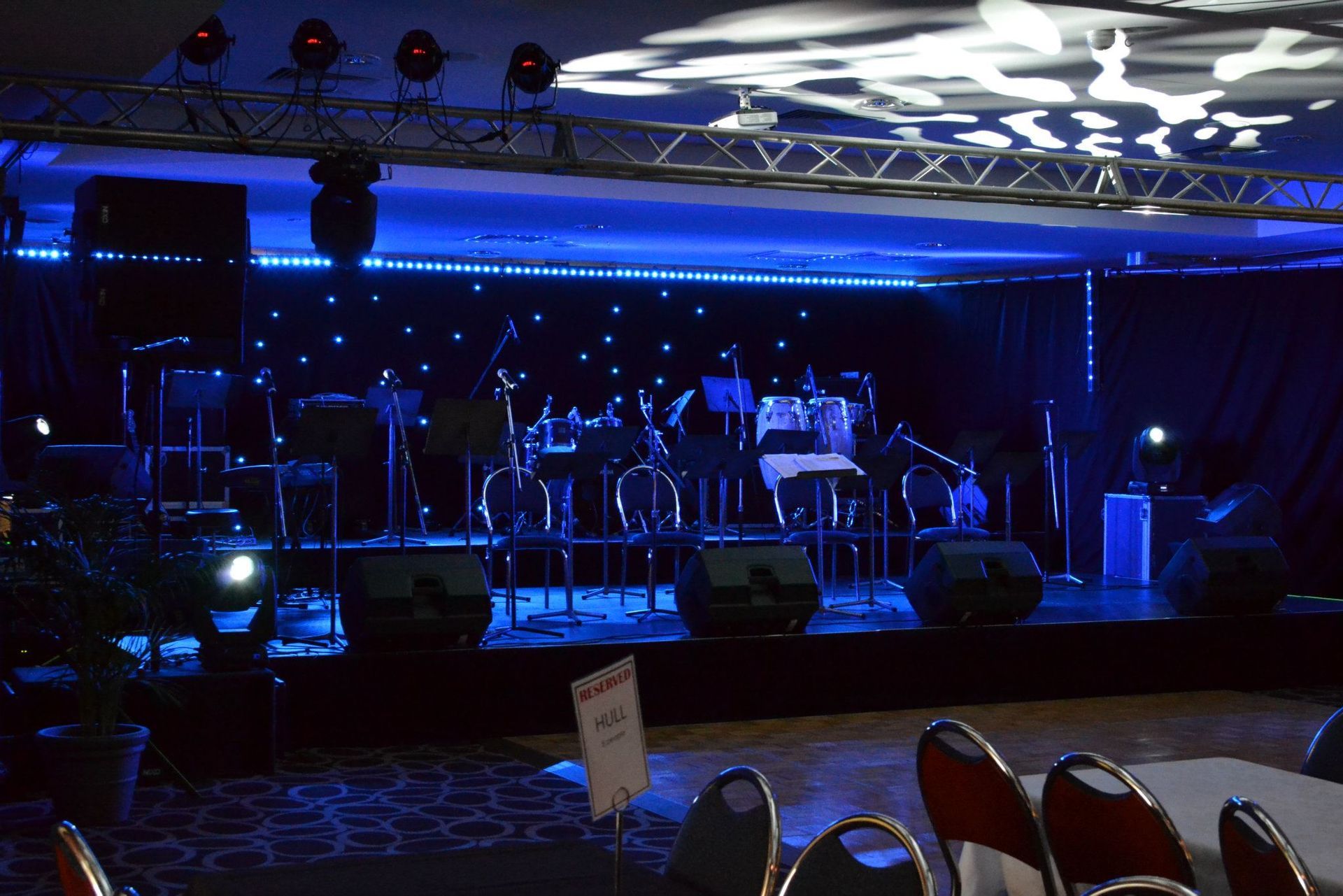 A Band Performing On Stage Under Blue Lights — Kennedy Amplifier Hire Service In South Mackay, QLD