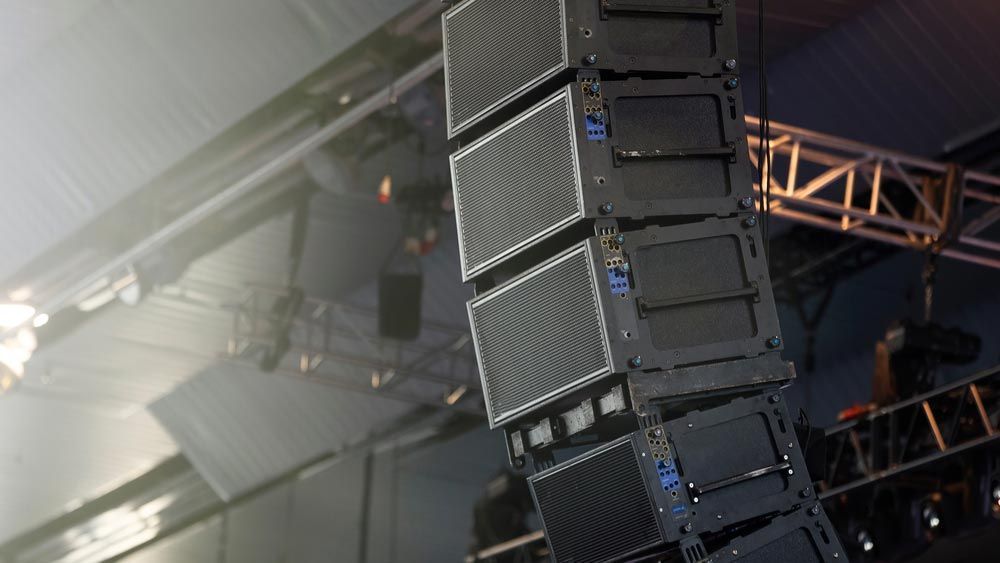 Array Of Black Speakers Hanging From A Metal Structure — Kennedy Amplifier Hire Service In South Mackay, QLD