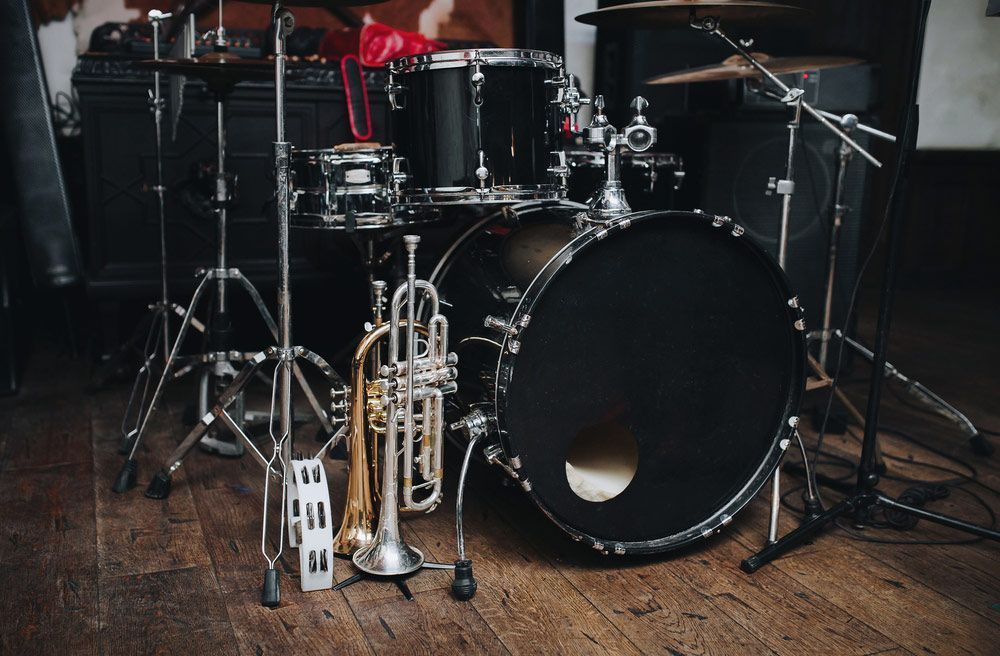 Drum Set With A Trumpet On A Wooden Floor — Kennedy Amplifier Hire Service In South Mackay, QLD