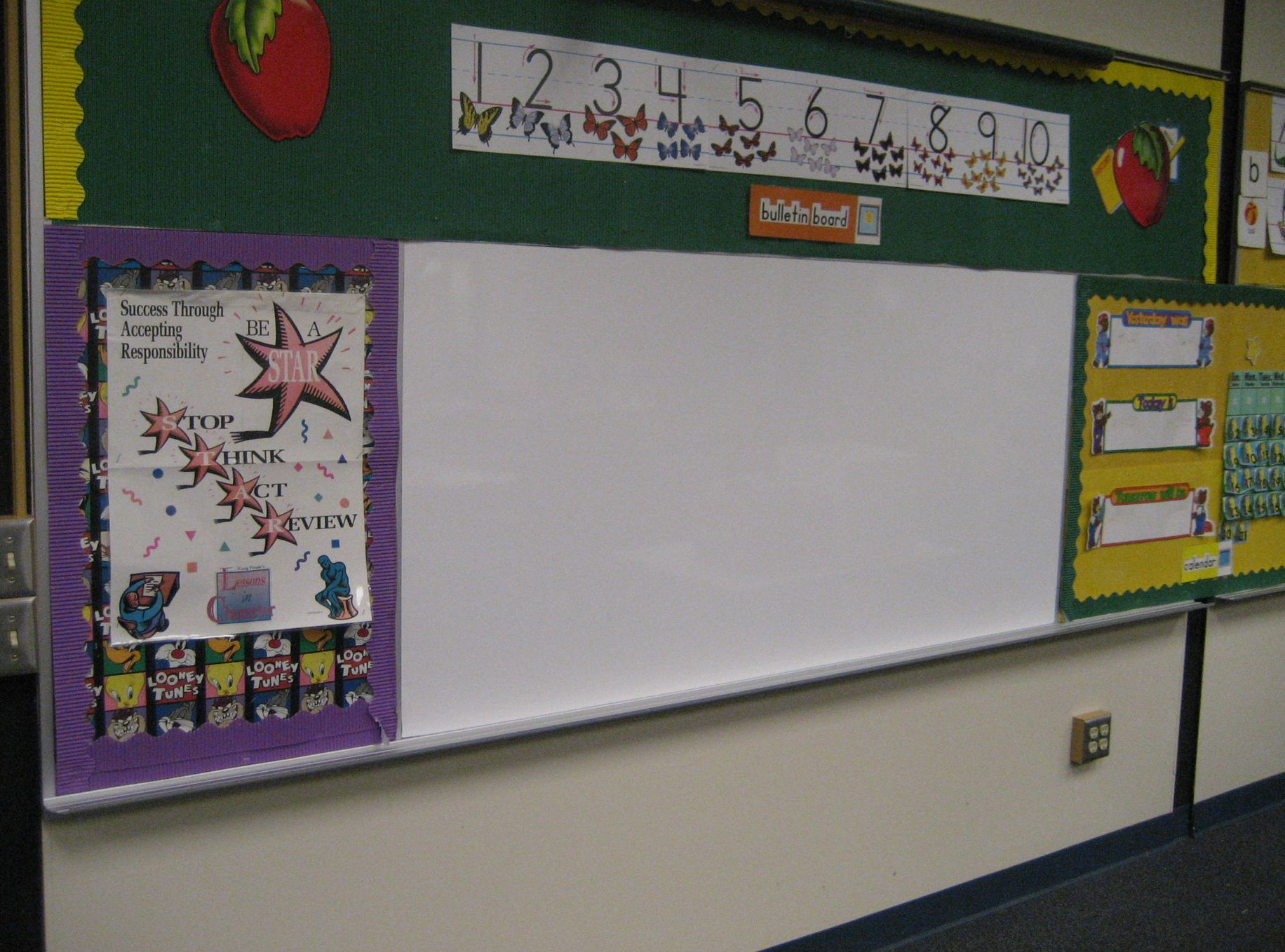 Elementary classroom bulletin board with a large blank white center, bordered in purple, yellow, and green.