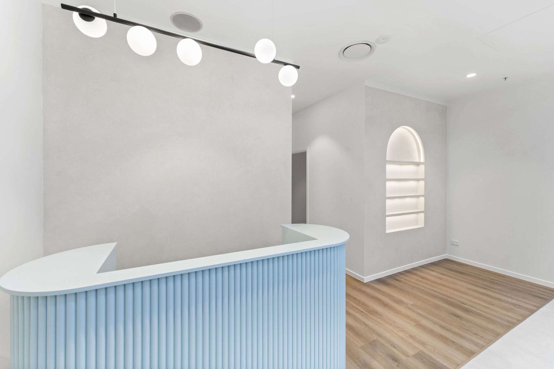 Light blue and white reception desk in a minimalist, modern office.