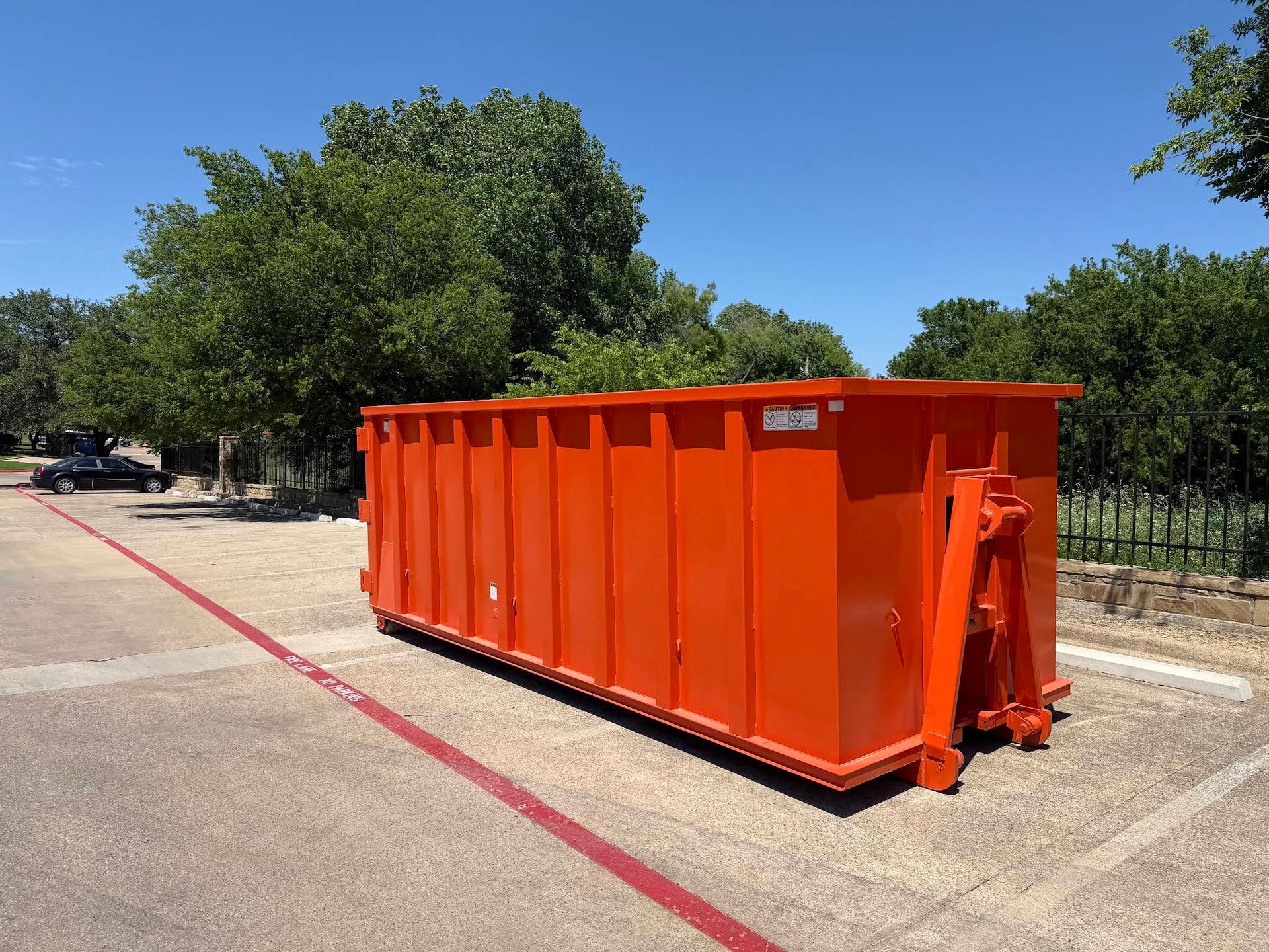 Orange roll off dumpster rental in a Fort Worth, TX driveway