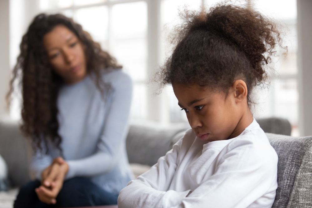 A Woman Is Talking To A Young Girl In A Library — The Red Chair Therapy in Blackwall, NSW