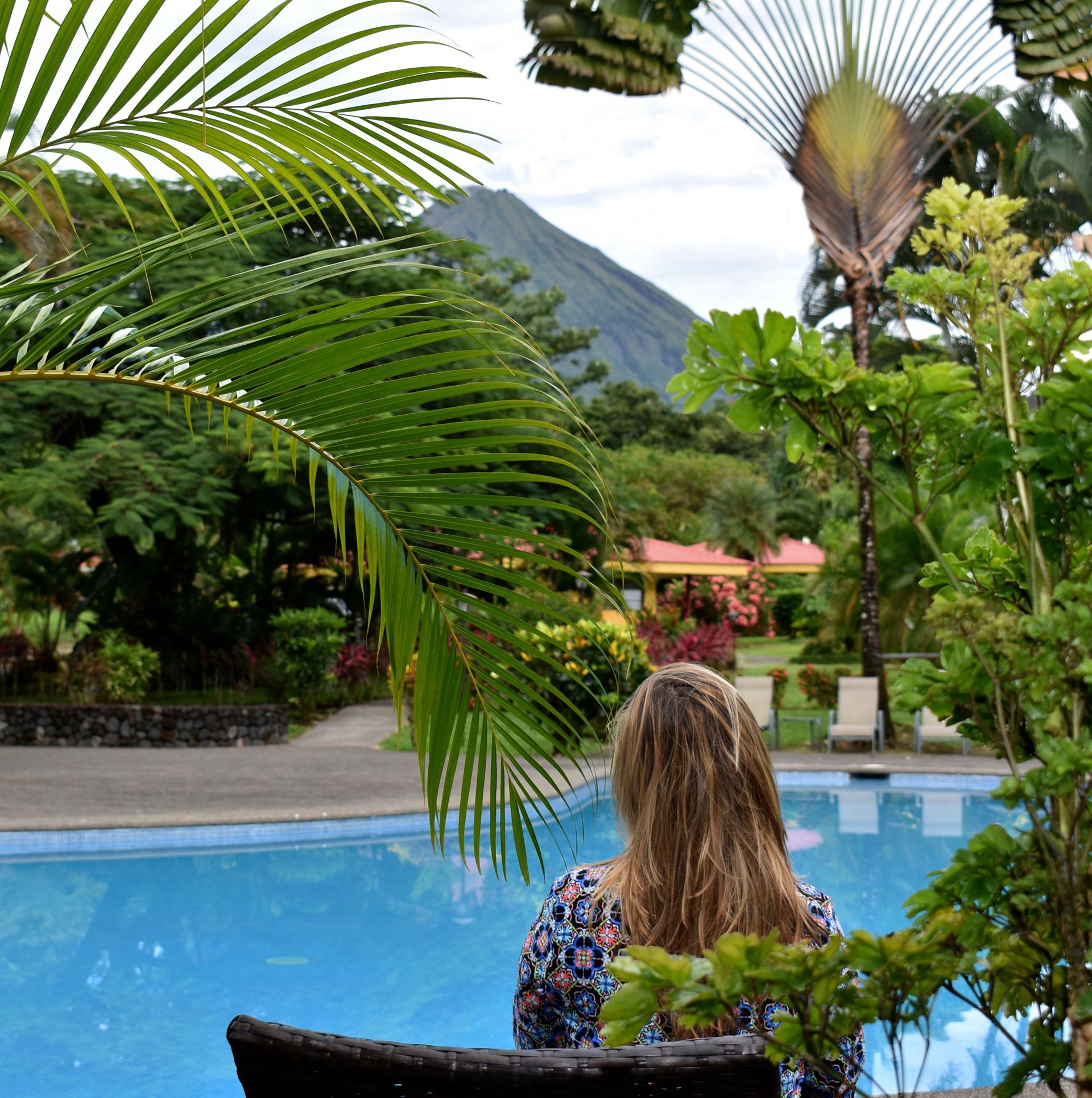 Área de comedor moderna con mesas de madera y estanterías decorativas en un ambiente minimalista