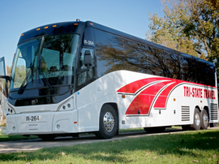 White Tri-State Trailways coach bus parked outdoors on a sunny day