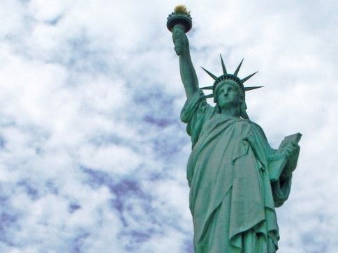 Statue of Liberty against a cloudy sky, torch raised high