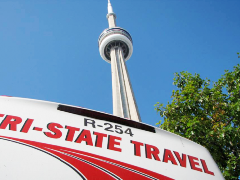 CN Tower above a Tri-State Travel sign against a blue sky