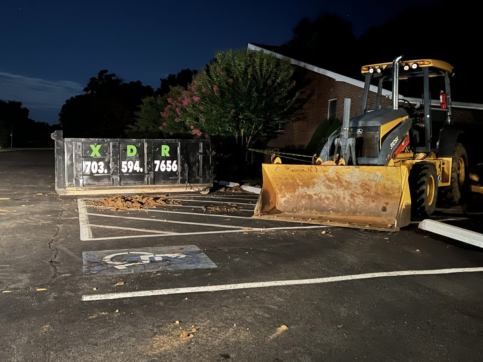 a bulldozer is parked in a parking lot at night