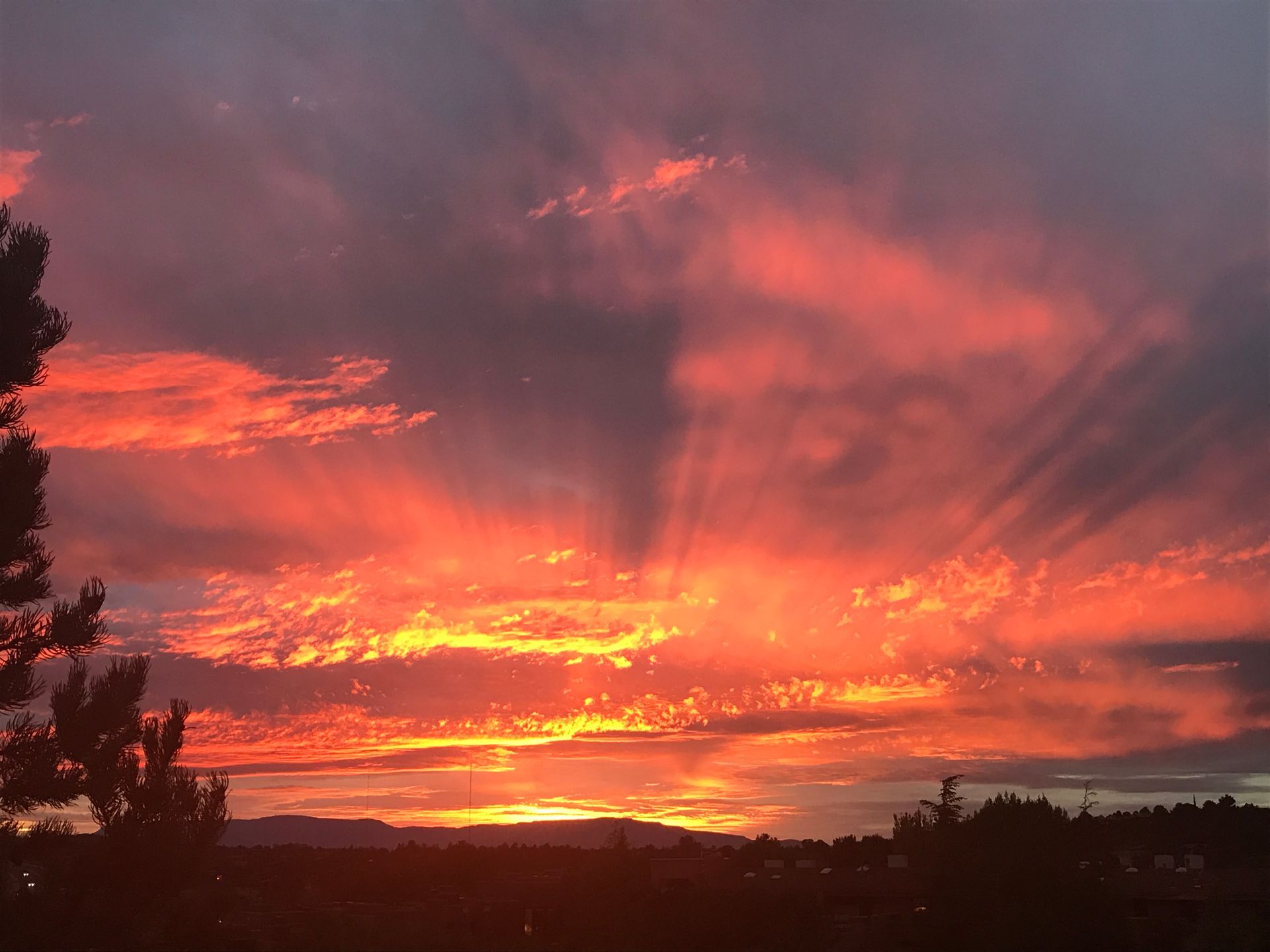 The sun is shining through the clouds at sunset.