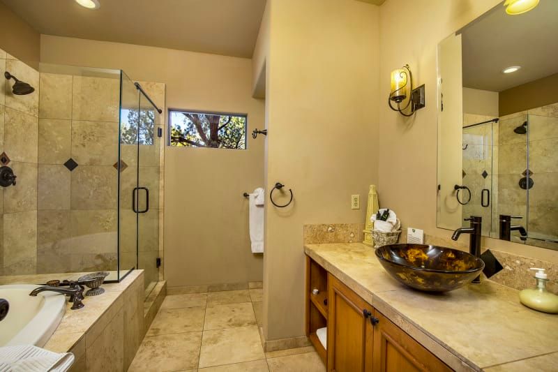 A bathroom with a sink , tub , shower and mirror.