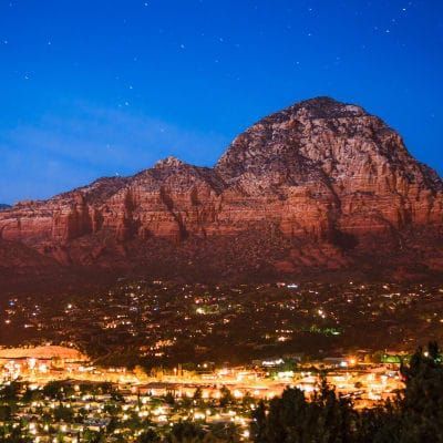 A city with a mountain in the background at night