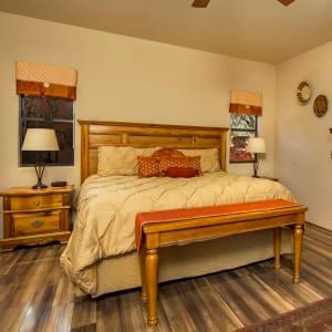 A bedroom with a king size bed and a bench.