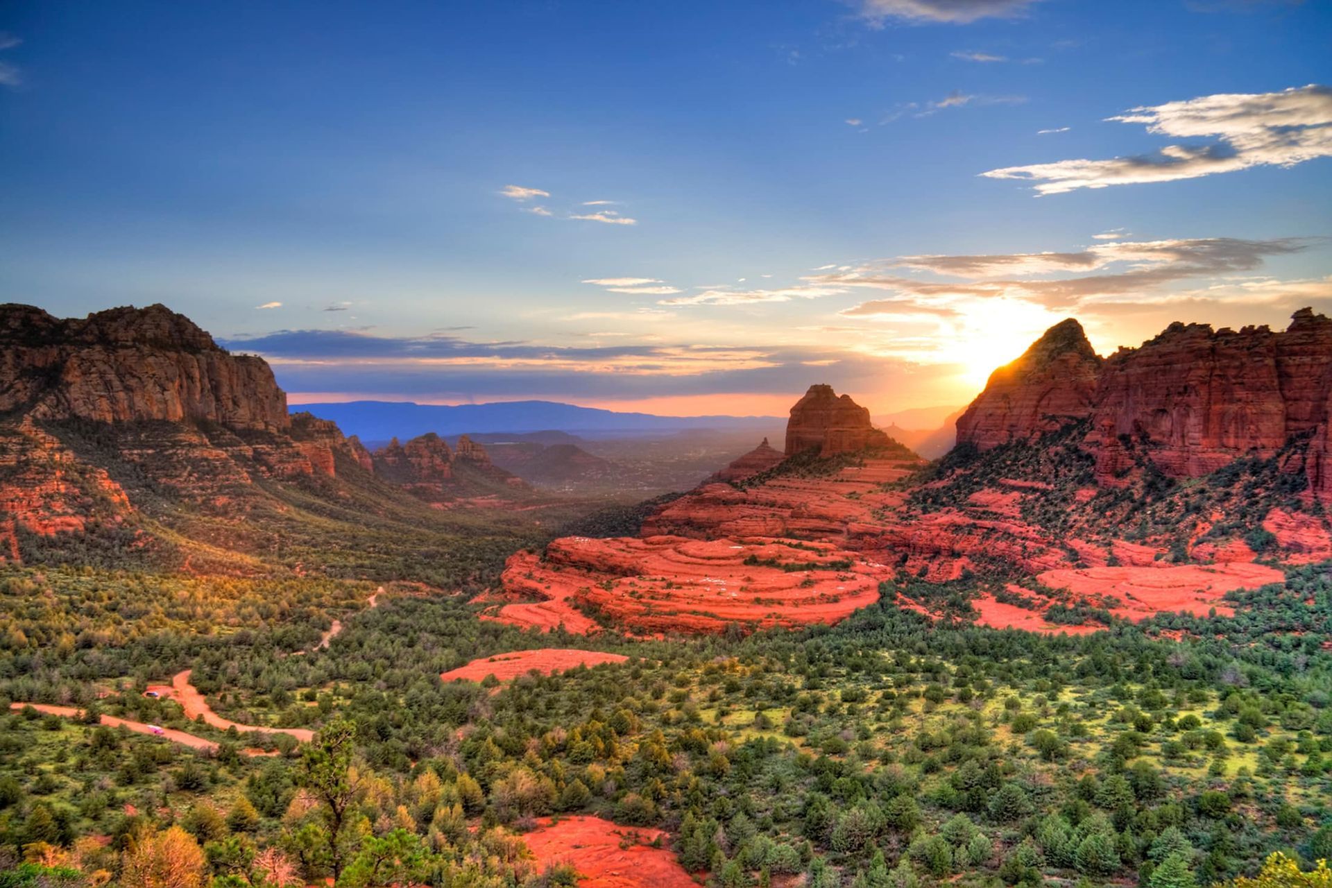 The sun is setting over the mountains in the desert.