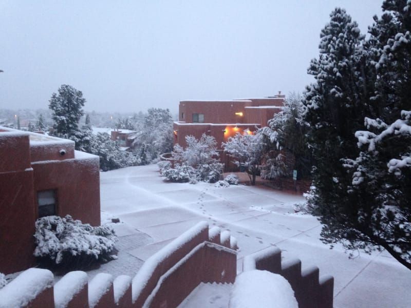 A snowy scene with stairs and buildings in the background