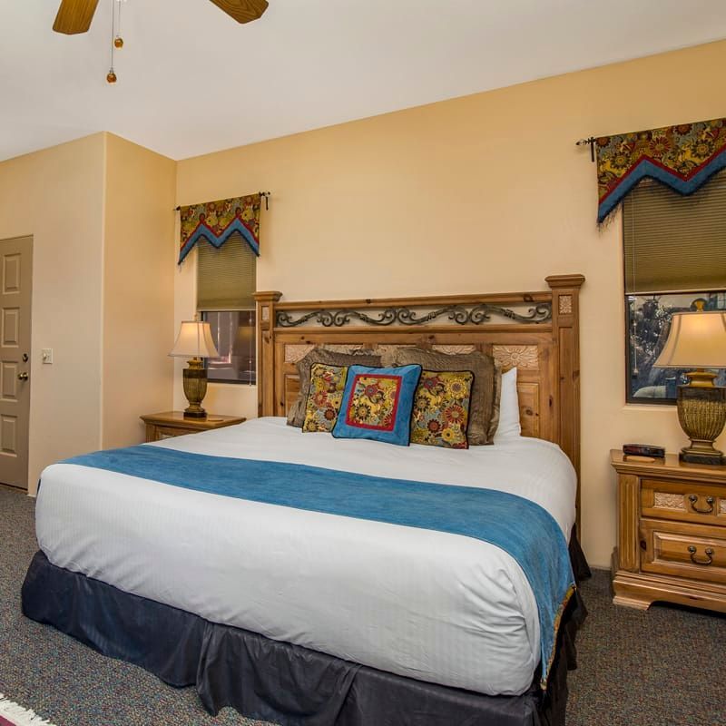 A bedroom with a king size bed and a ceiling fan