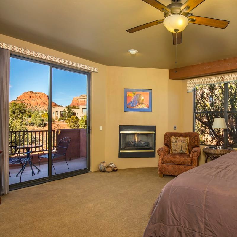 A bedroom with a fireplace and sliding glass doors
