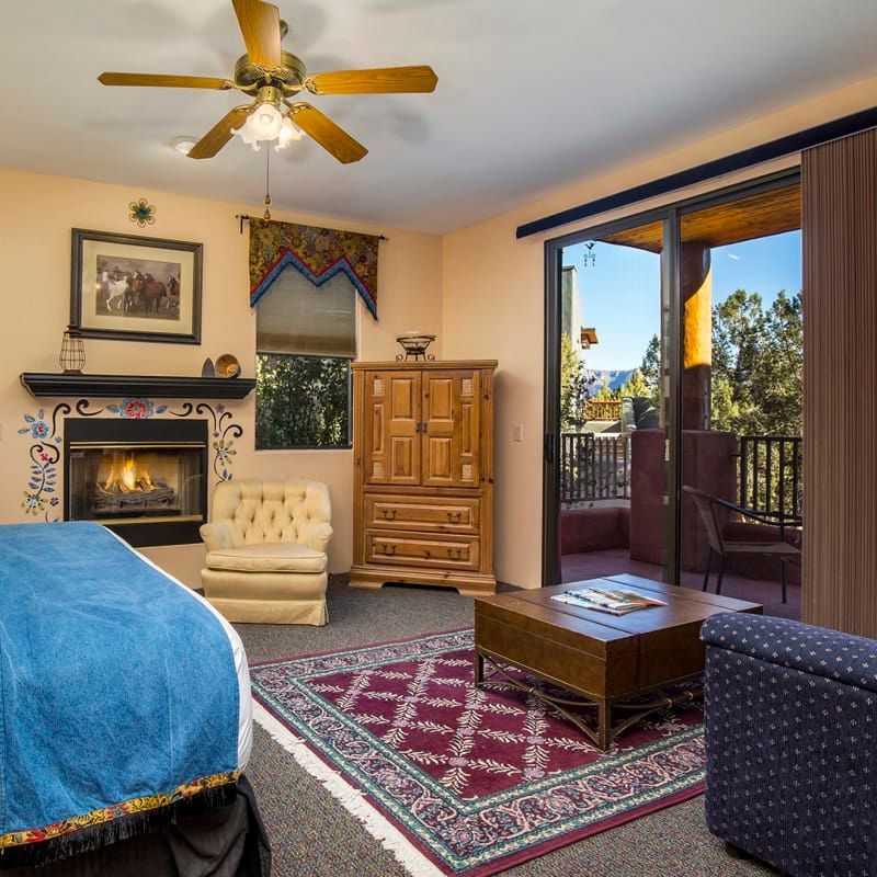 A bedroom with a fireplace and a ceiling fan