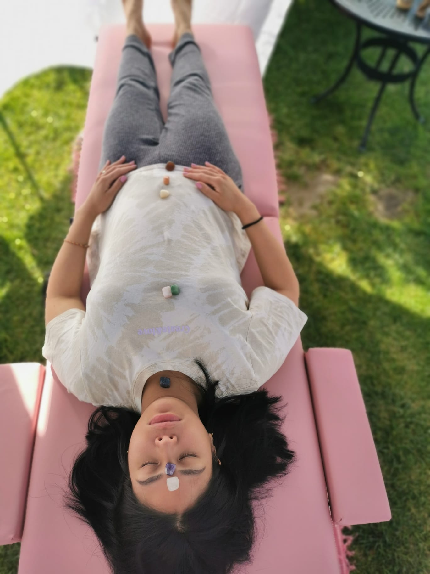 A woman is laying on a pink bed with her eyes closed.
