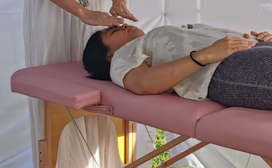A woman is laying on a pink table getting a massage.