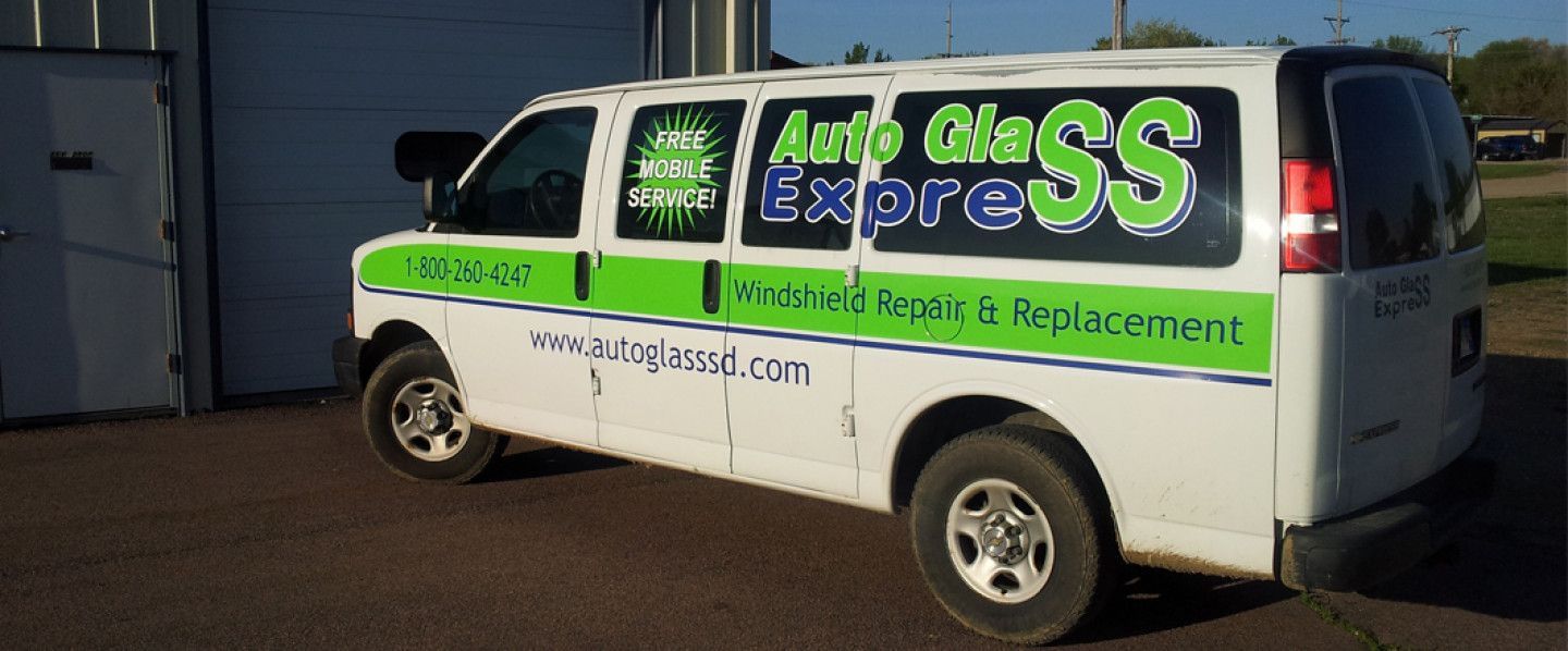 White service van with green “SS Express” signage parked outdoors at a building.