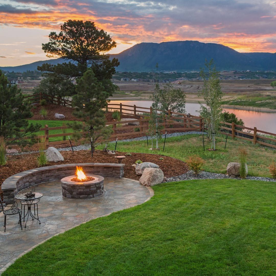 Backyard fire pit overlooking a river, mountains, and sunset sky