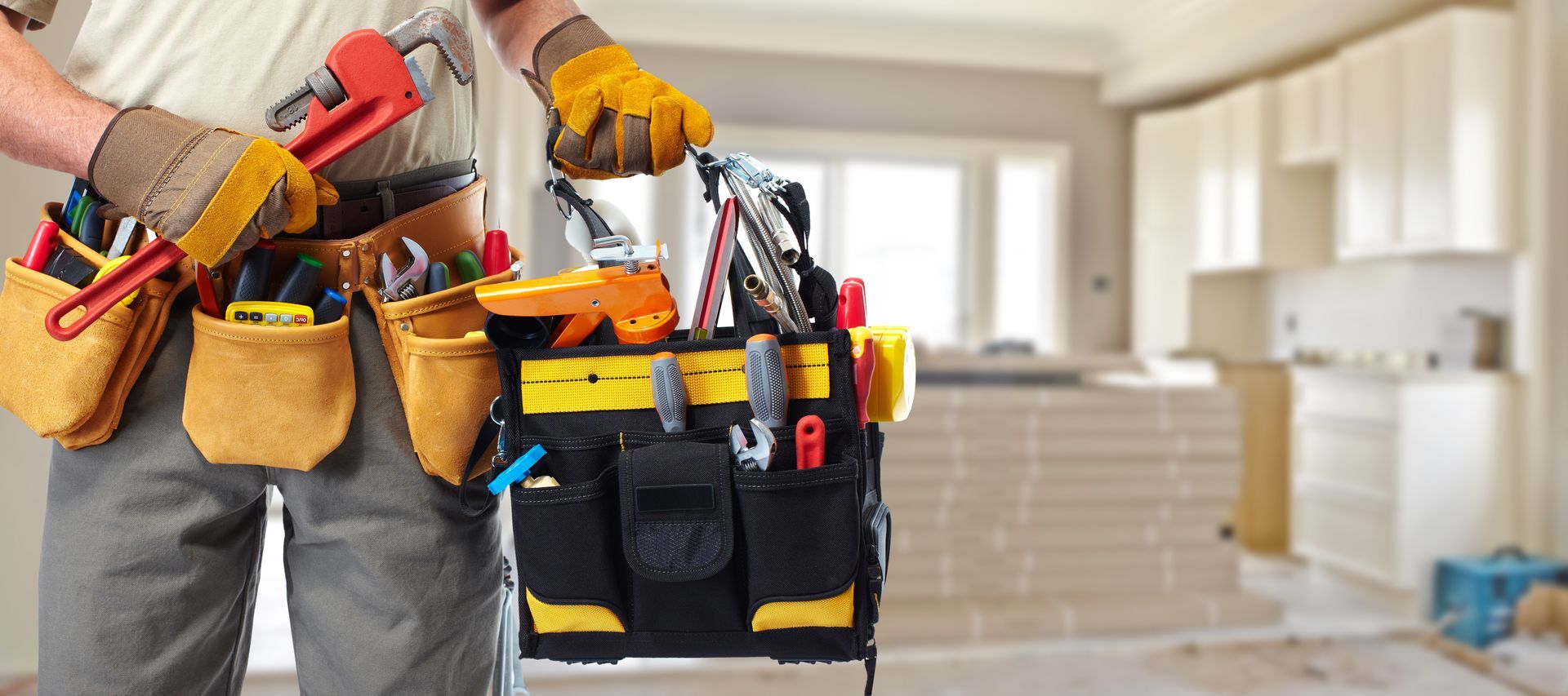 A man is holding a toolbox full of tools.