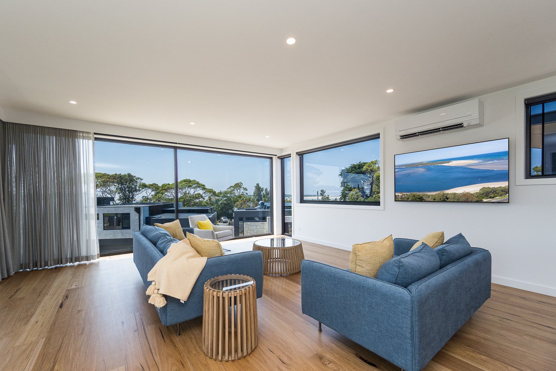 A living room with a blue couch and two chairs