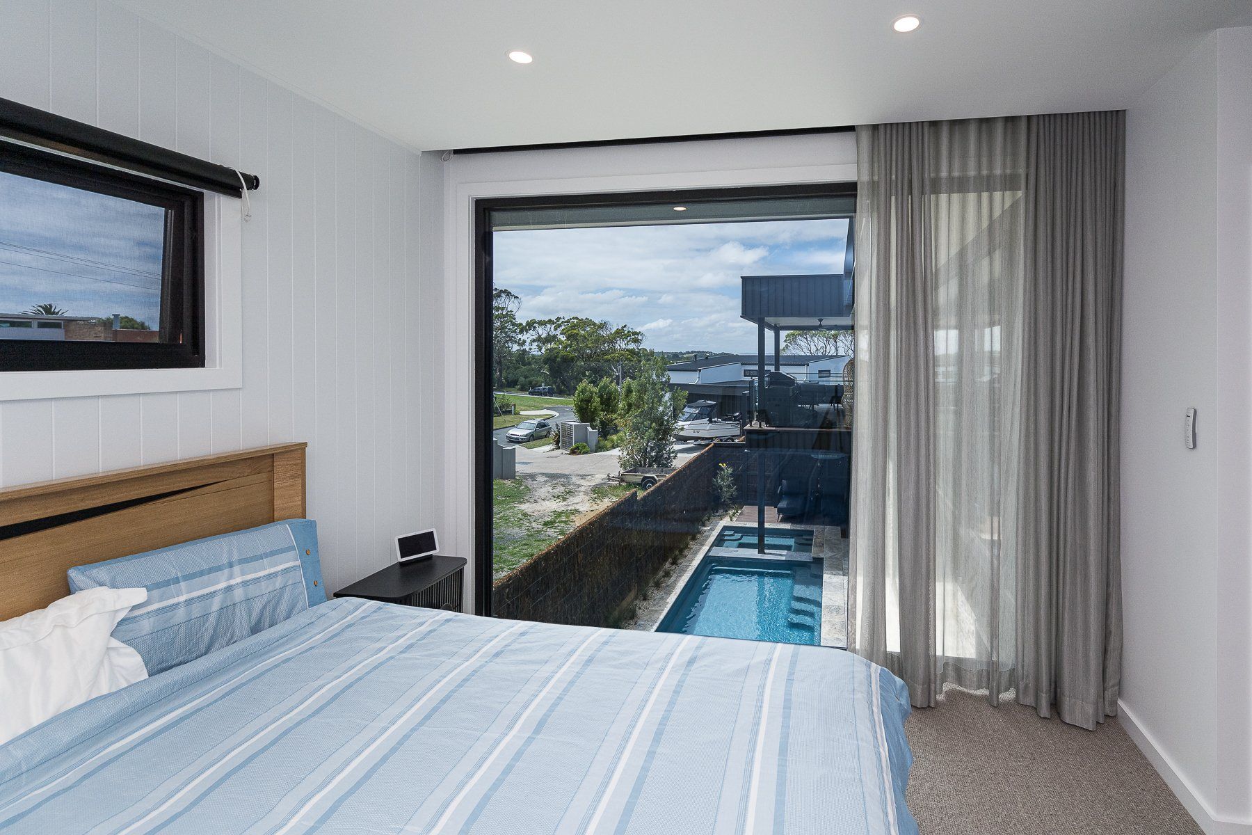 A bedroom with a sliding glass door leading to a pool.
