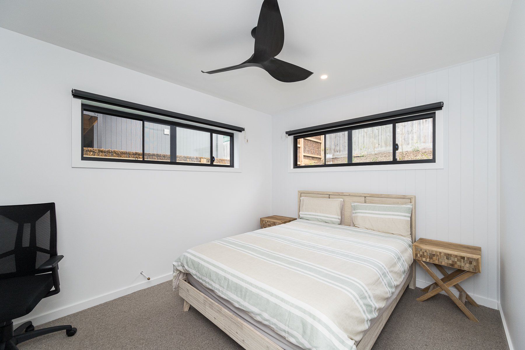 A bedroom with a bed and a ceiling fan.