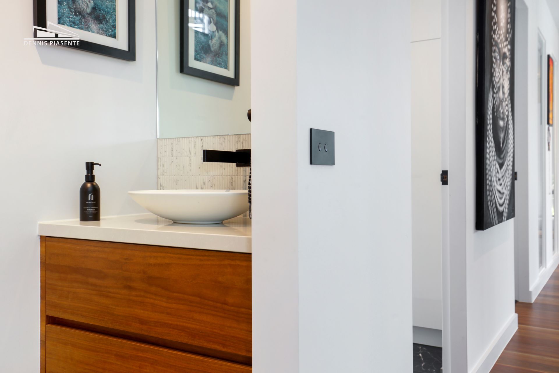 A bathroom with a sink , mirror and wooden cabinets.