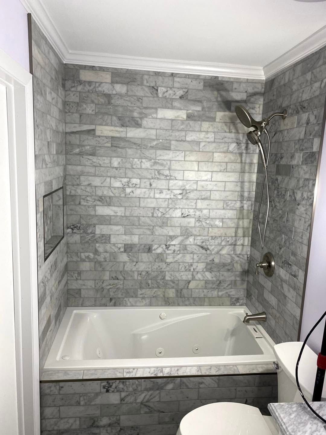 Modern bathroom with stone tile walls and a white bathtub/shower combo