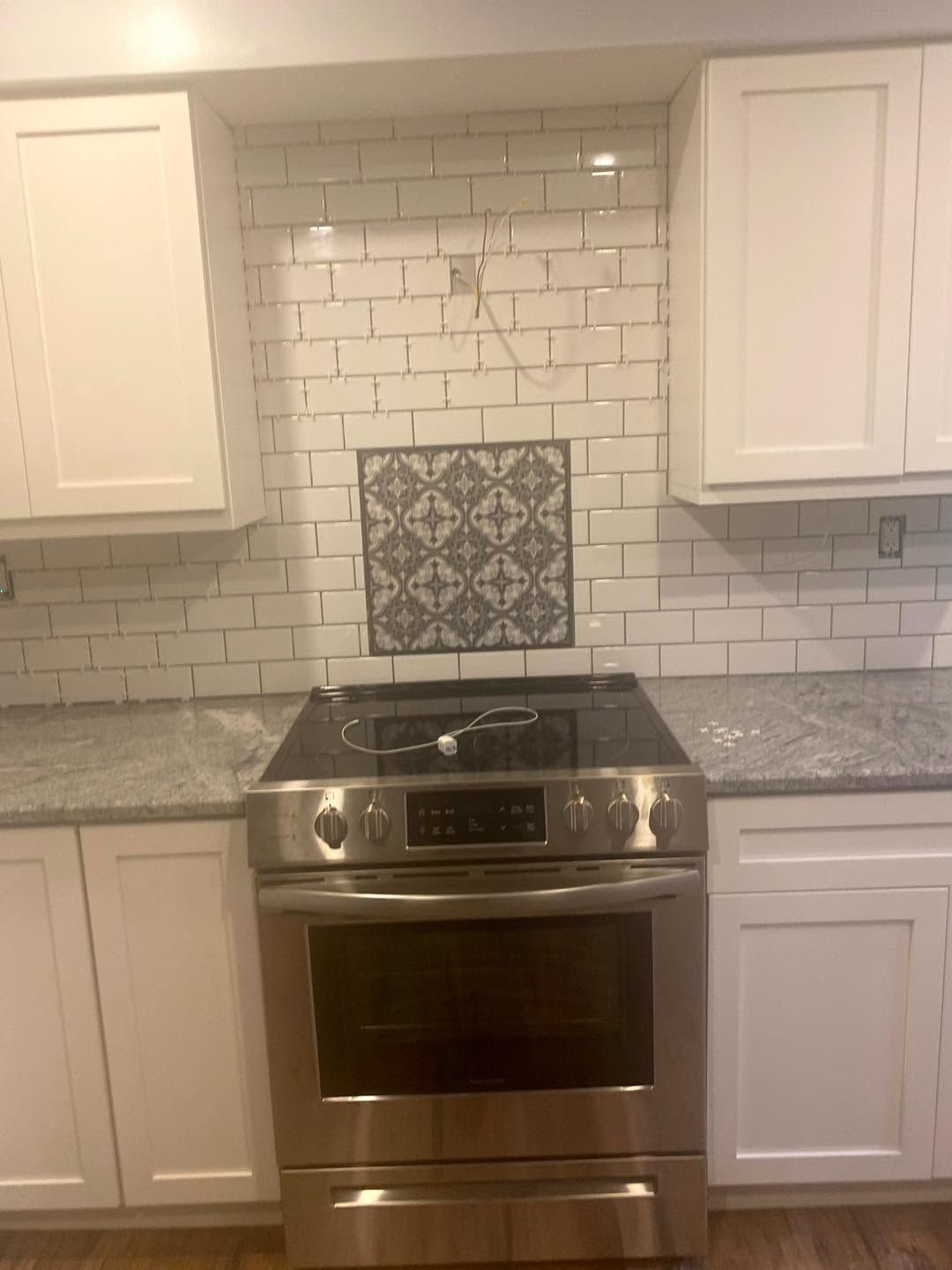 Modern kitchen with stainless steel stove, white cabinets