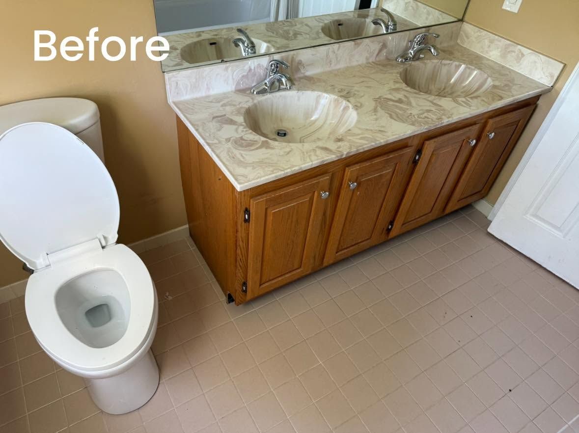 Before view of a bathroom with a toilet and wooden double-sink vanity with beige countertop.