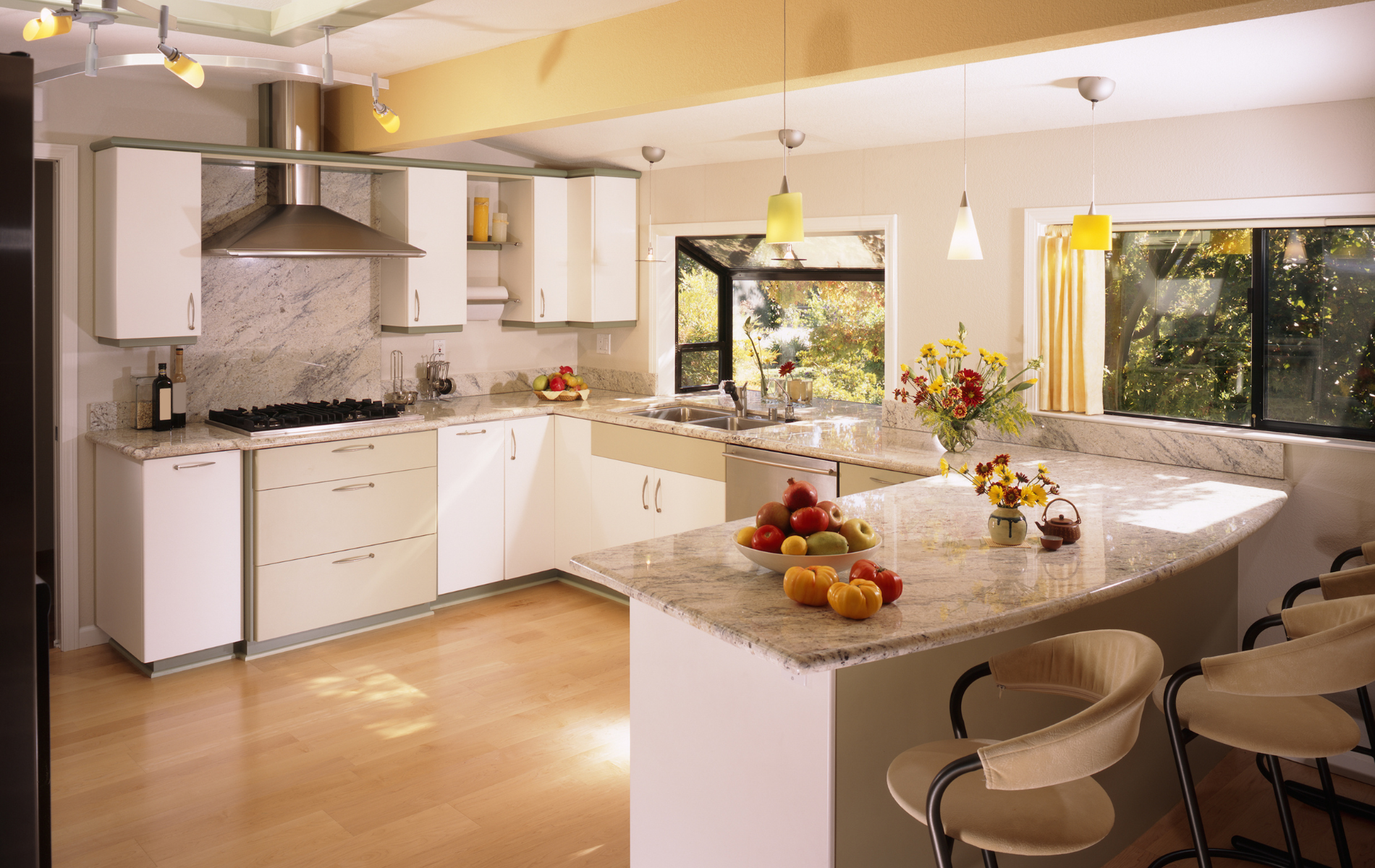 Bright modern kitchen with white cabinets, granite island, fruit bowl, and large window view