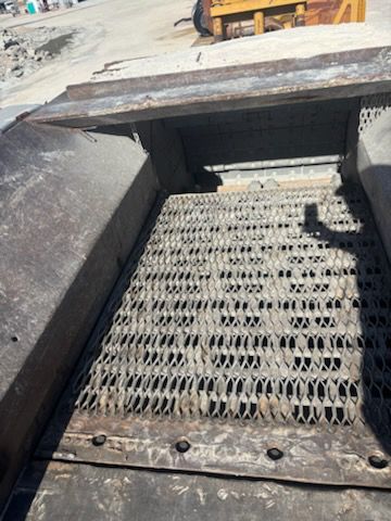 Metal grate inside of a large industrial machine, likely for sifting materials.