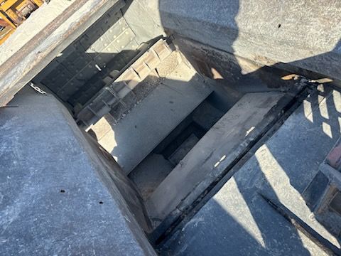 Looking down a stone stairwell with visible steps and shadows.