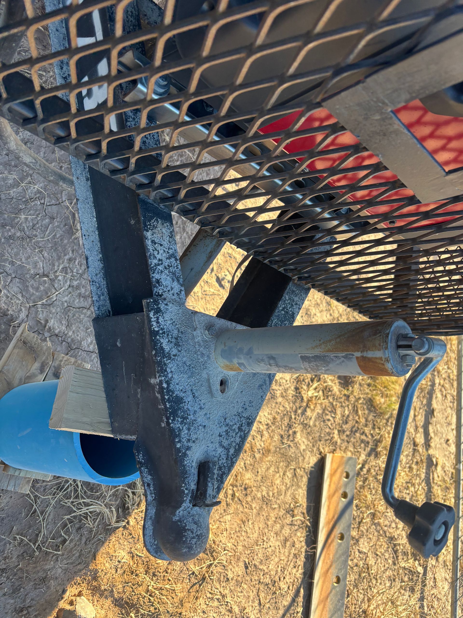 Trailer tongue with a jack, with a metal basket above.