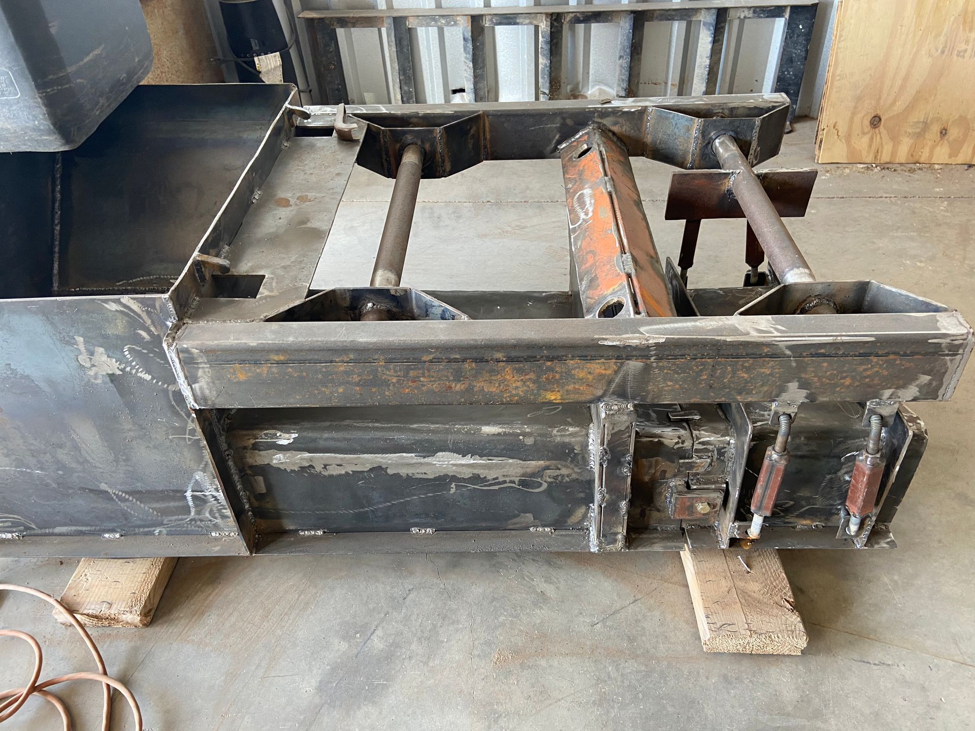 Black metal machinery part on wooden blocks.