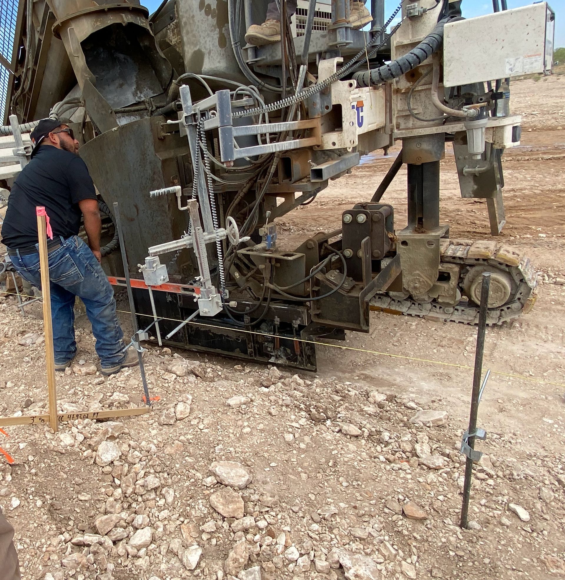 Man operates drilling machine in outdoor setting.