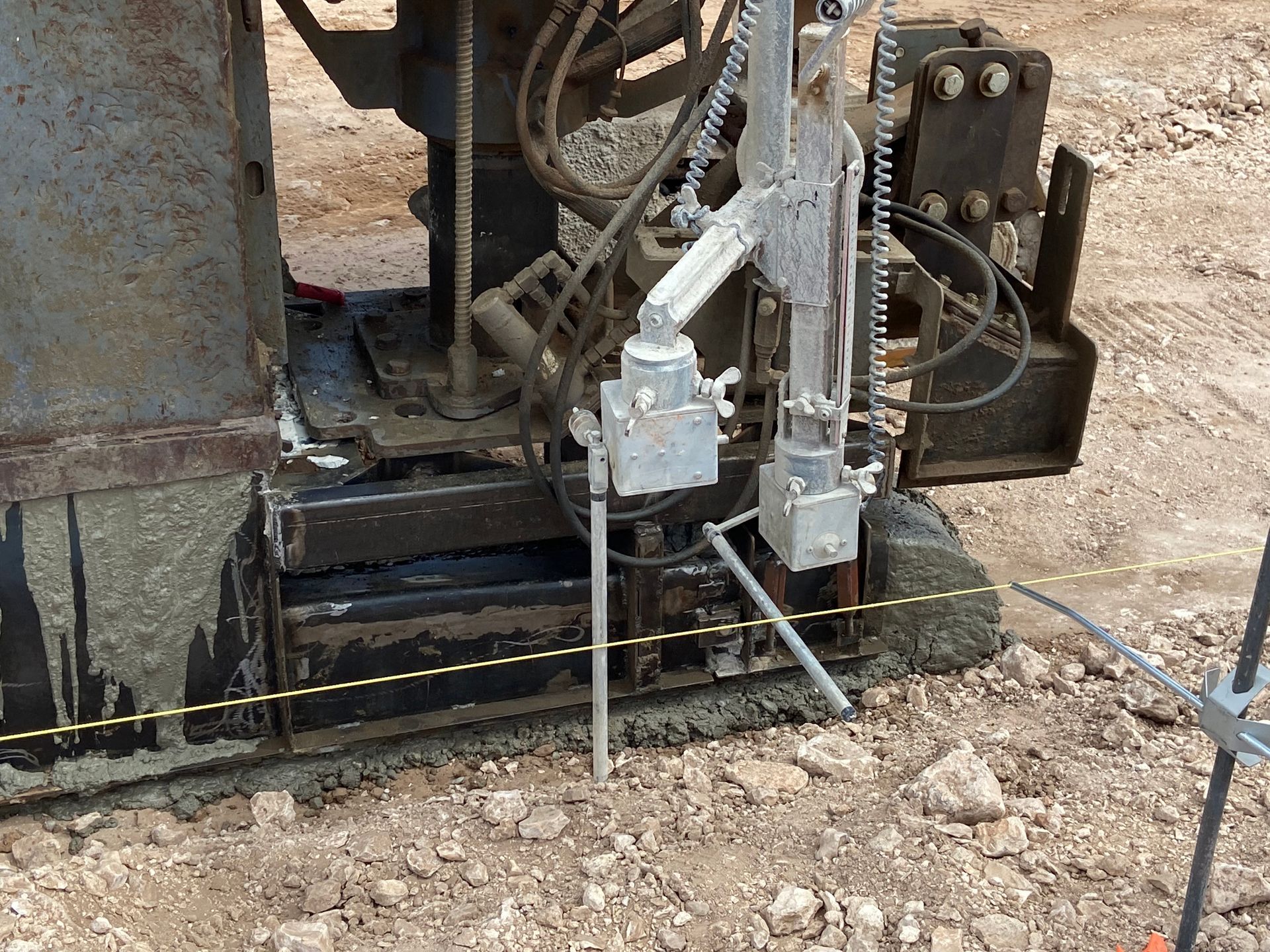 Drilling equipment on a construction site. Gray machine with metal arms, drilling into dirt.