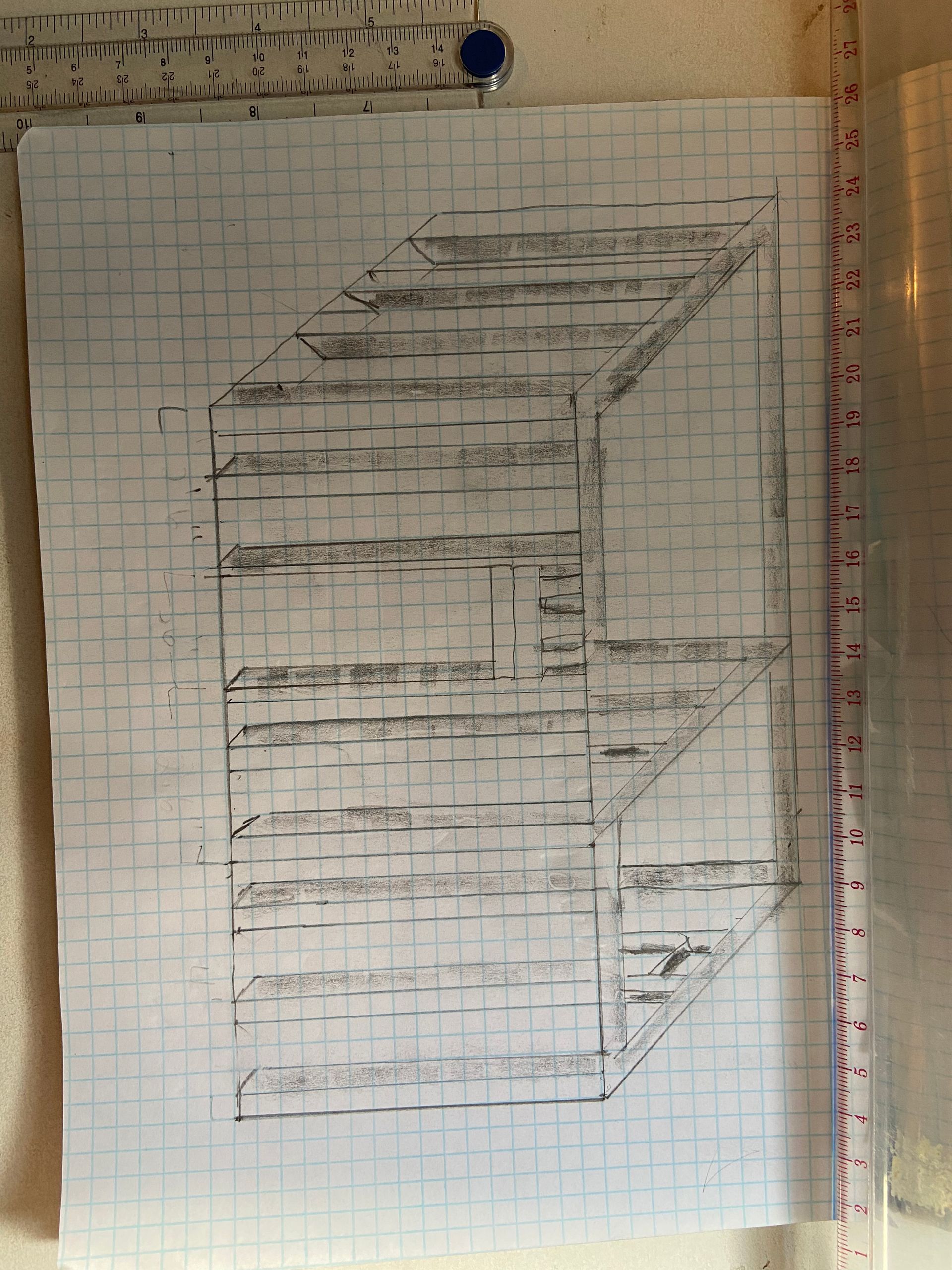 Sketch of a multi-tiered structure, likely shelves, drawn in perspective on graph paper, attached with a pushpin.