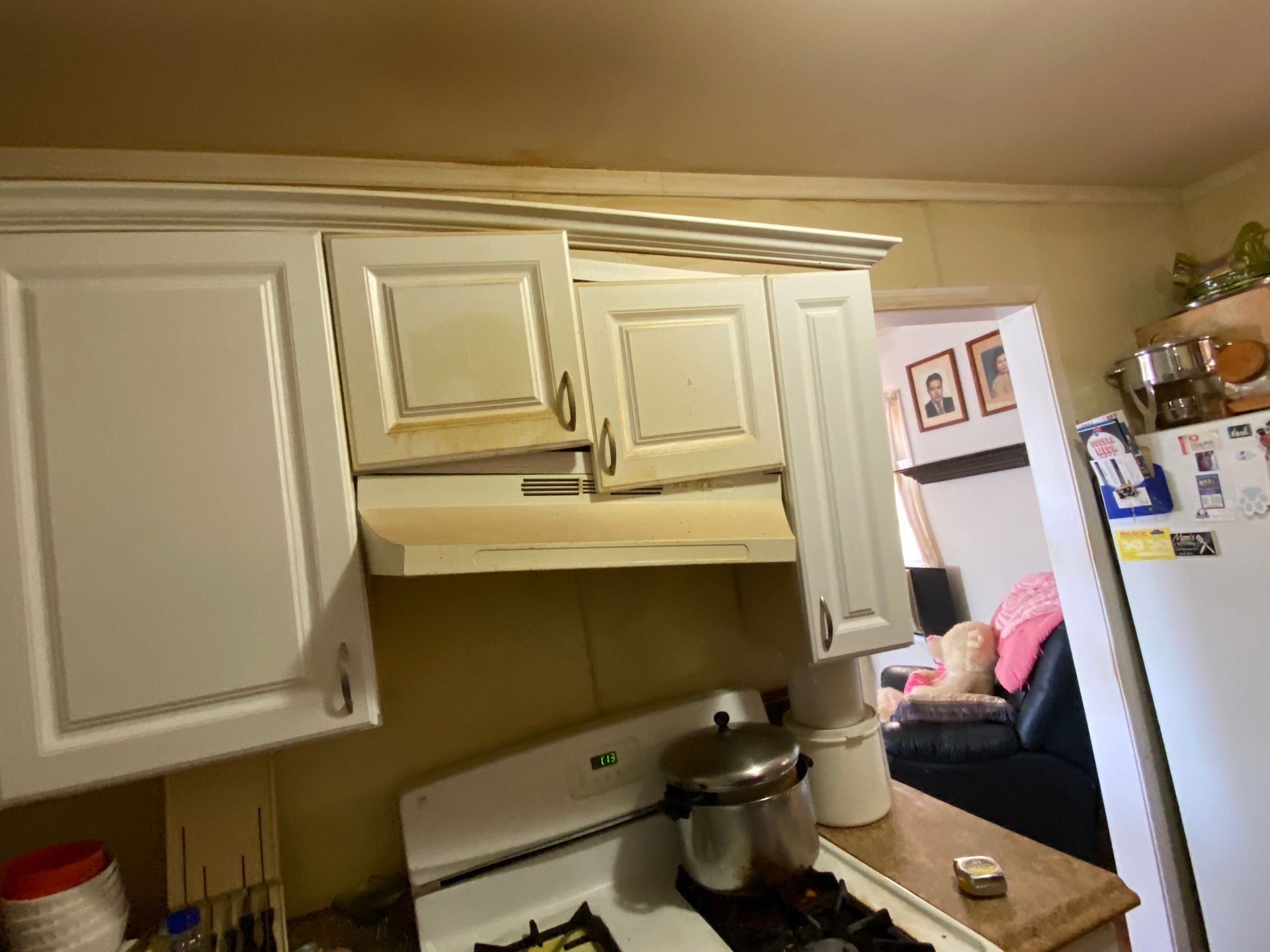 White kitchen cabinets with range hood above a stove.
