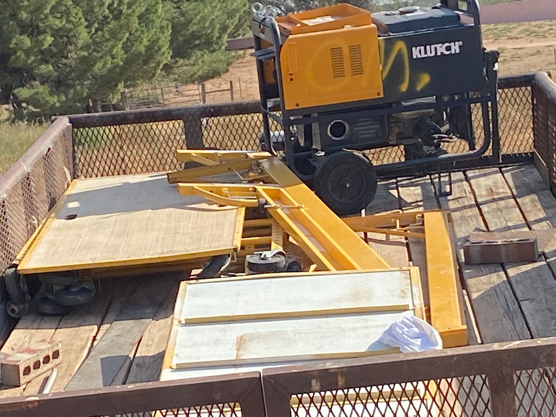 Yellow and black generator and equipment loaded in a truck bed.