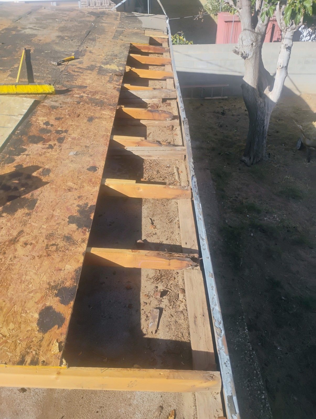 Construction site: rusted metal with wooden supports, level, and tool.