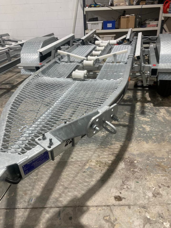 A Metal Boat Trailer With Rollers and a Grated Walkway — In Tune Marine in Mackay, QLD
