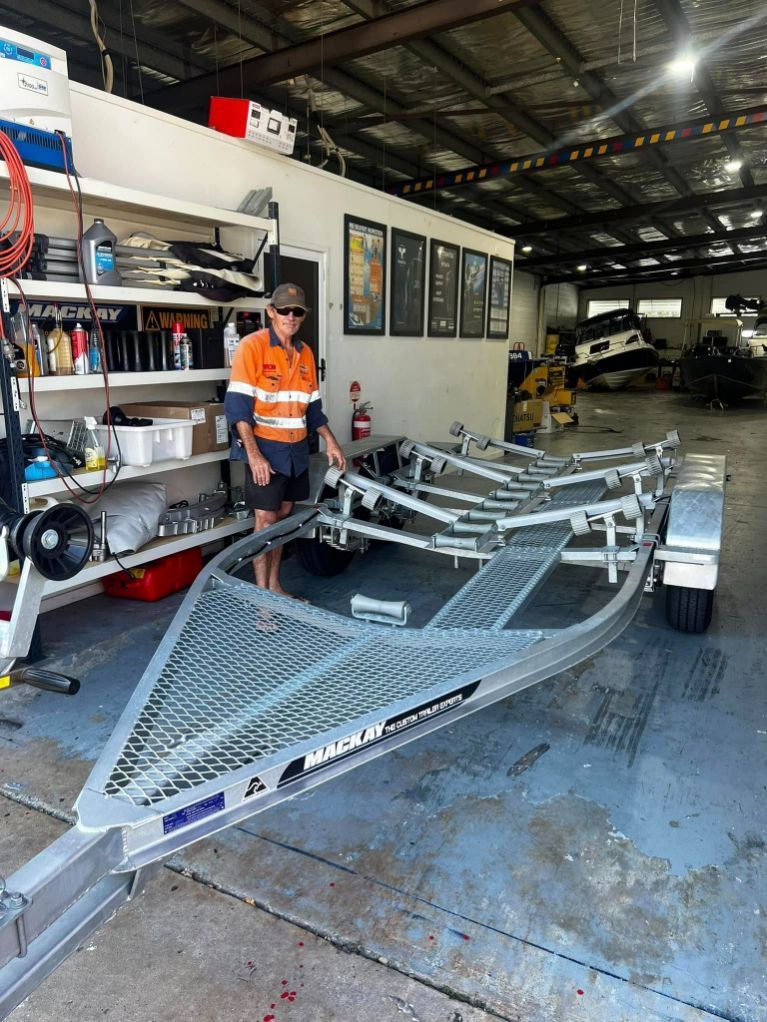 Man Stands Next to a New Boat Trailer Inside a Workshop — In Tune Marine in West End, QLD