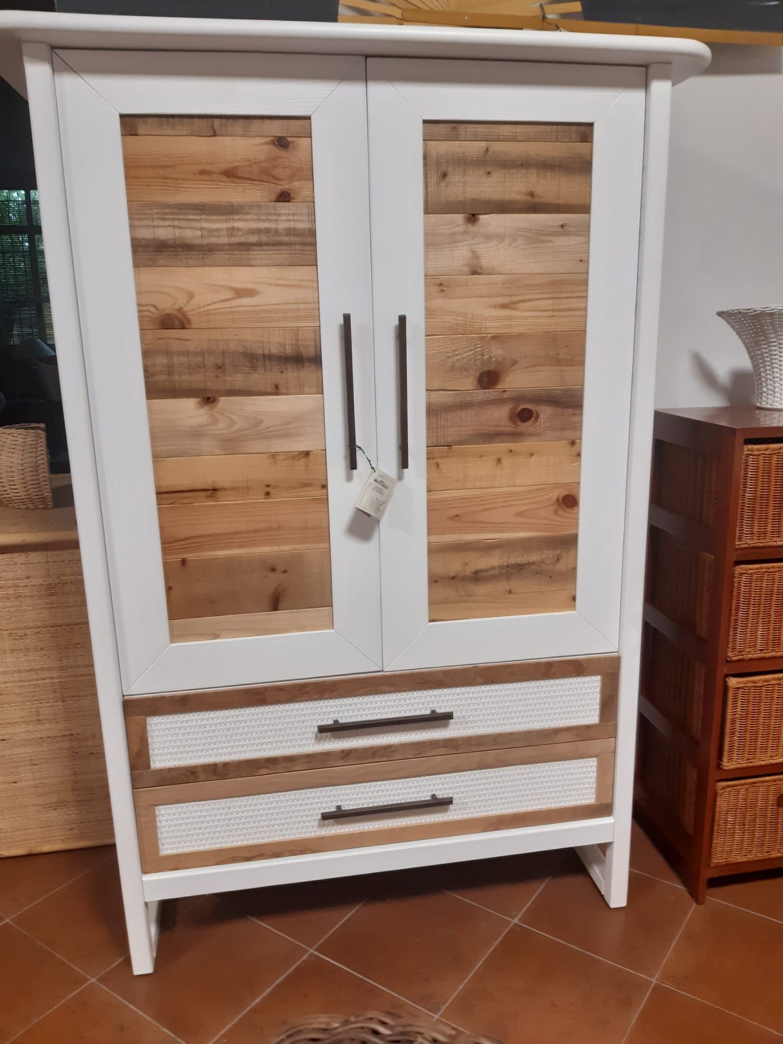 Un mobile bianco con ante e cassetti in legno in una stanza