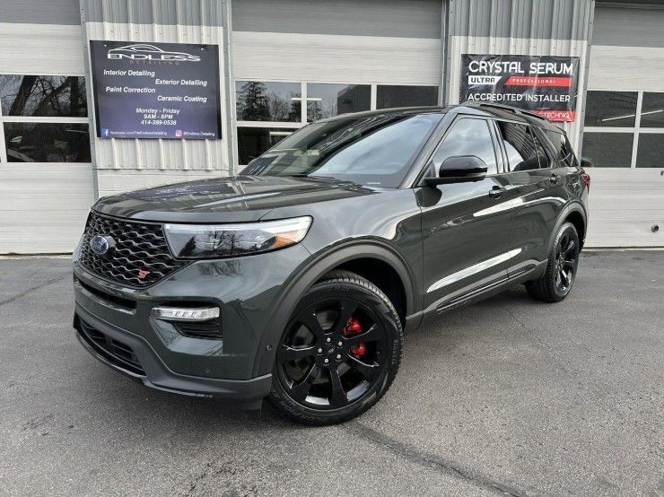 Dark gray SUV parked outside a dealership, front three-quarter view with black wheels and red brake calipers